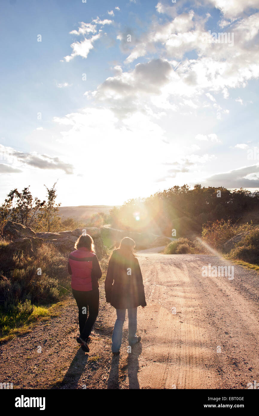 Rear view of young woman walking on country road Stock Photo - Alamy