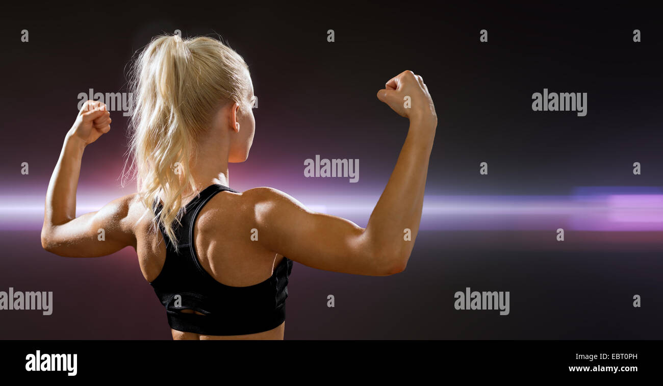 sporty woman from the back flexing her biceps Stock Photo