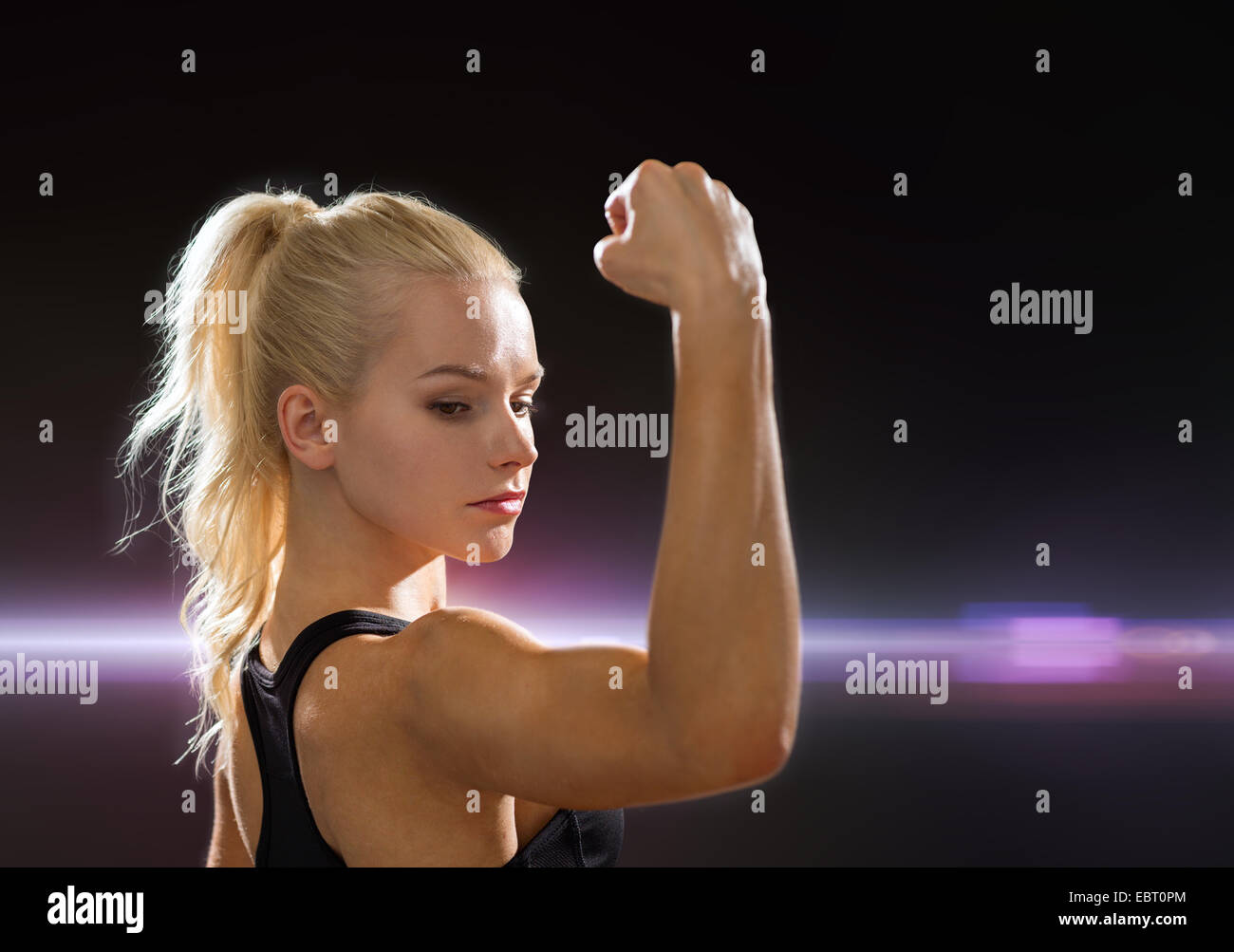 close up of athletic woman flexing her biceps Stock Photo
