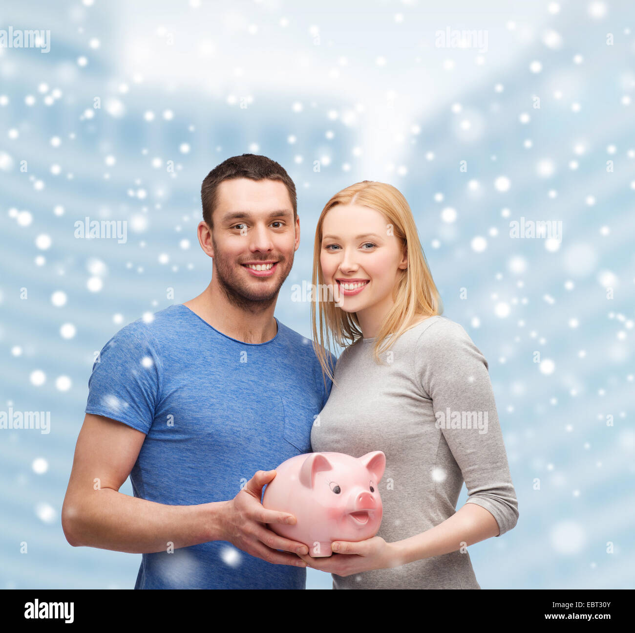smiling couple holding big piggy bank Stock Photo - Alamy