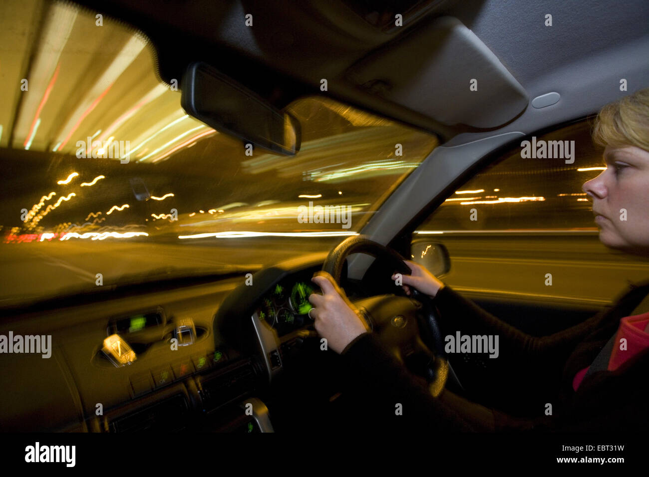 woman driving at night on motorway, United Kingdom, England Stock Photo