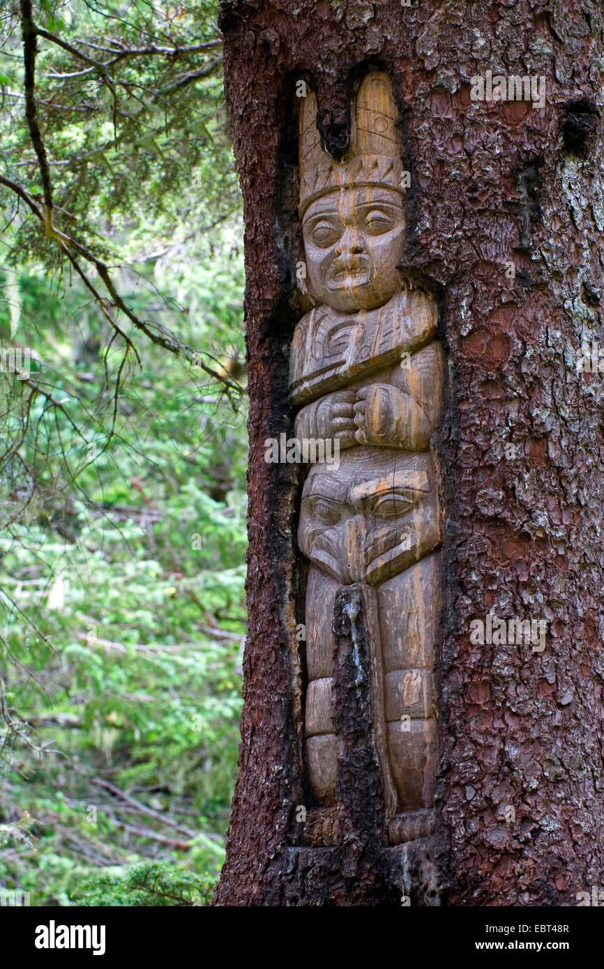 Tlingit carving at the trunk of a living tree symbolising a mythological caretaker, USA, Alaska, Juneau Stock Photo