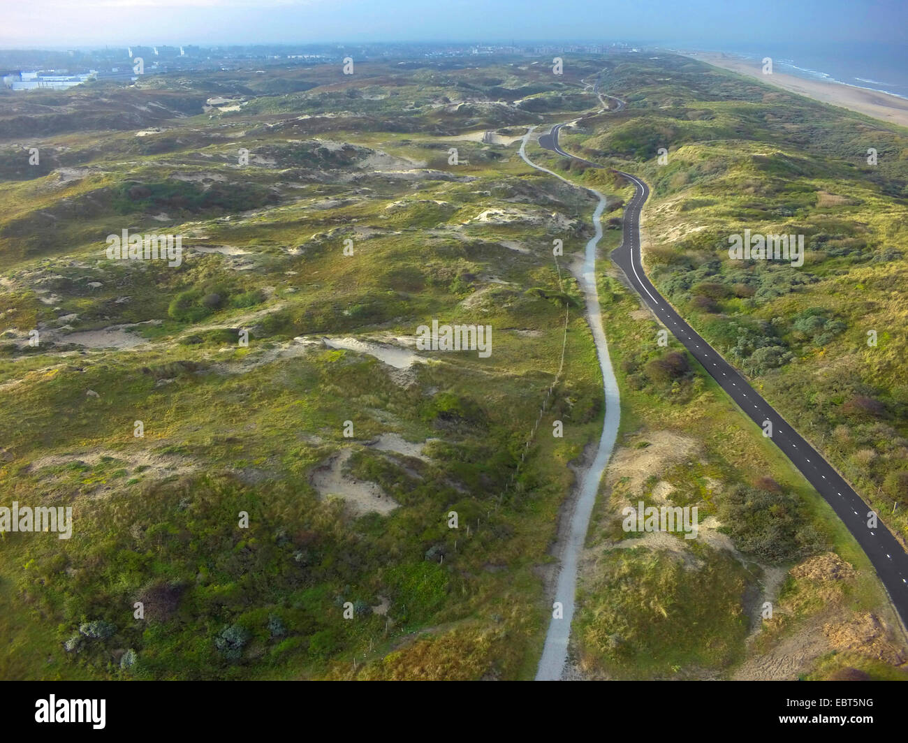 aerial view to road and bike way in grass-grown dunes at the North Sea ...