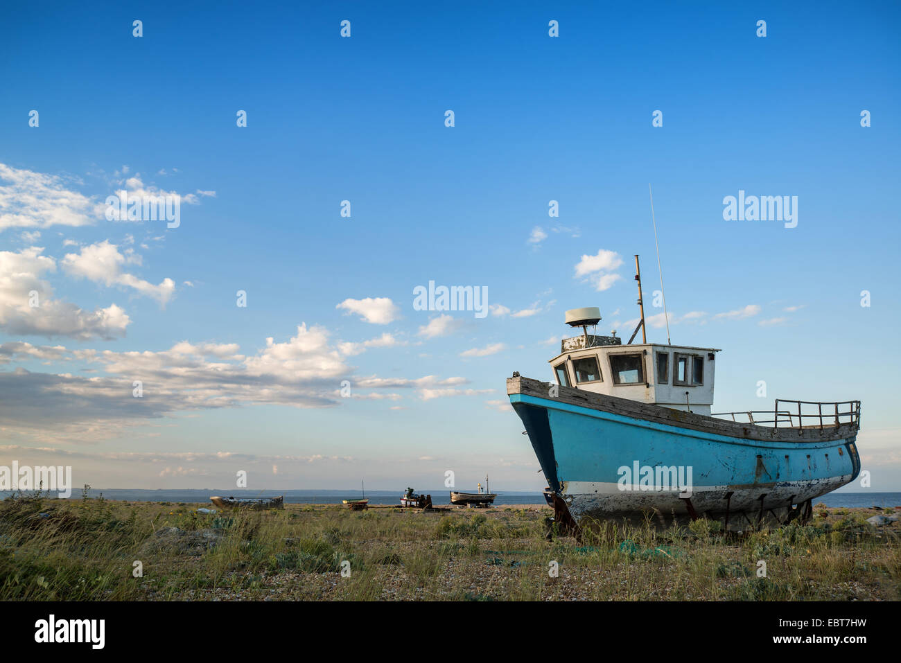 Abandoned fishing boat on shingle beach landscape at sunset Stock Photo ...