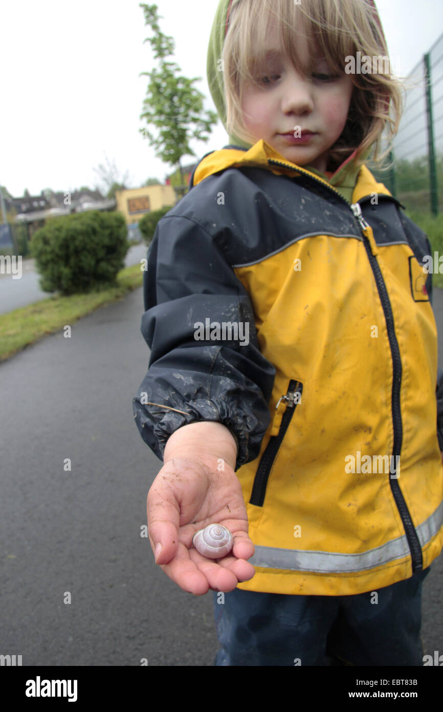 little boy with a snail in his hand, Germany Stock Photo