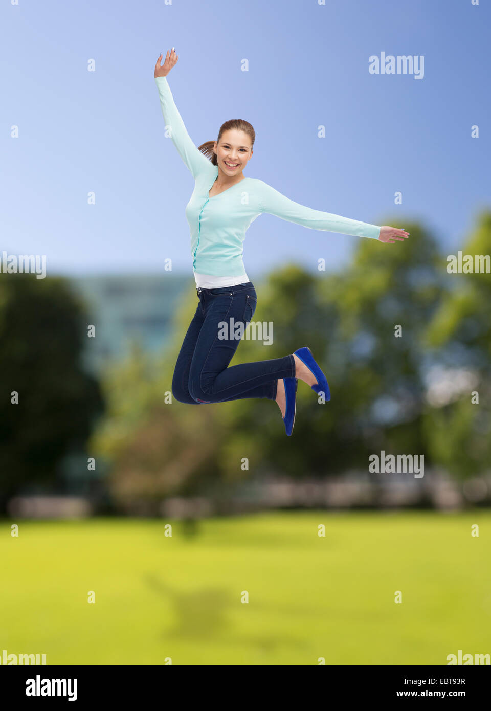 smiling young woman jumping in air Stock Photo - Alamy