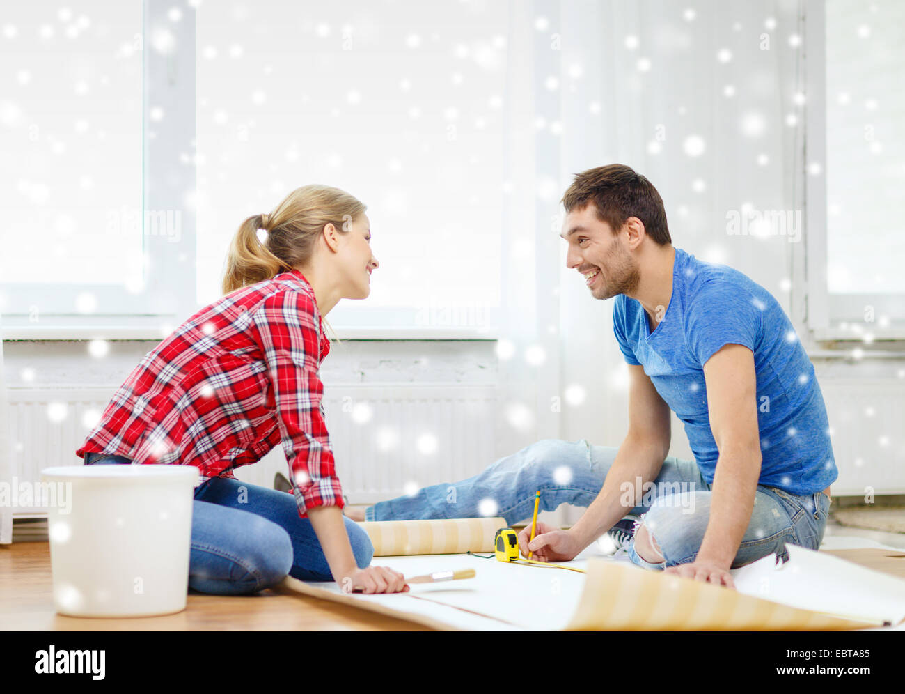 smiling couple measuring wallpaper Stock Photo