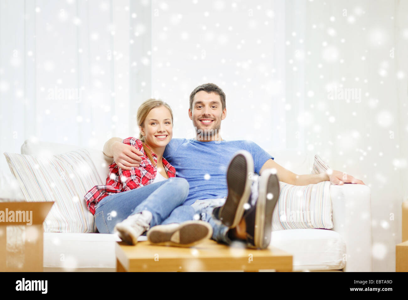 smiling couple relaxing on sofa in new home Stock Photo - Alamy