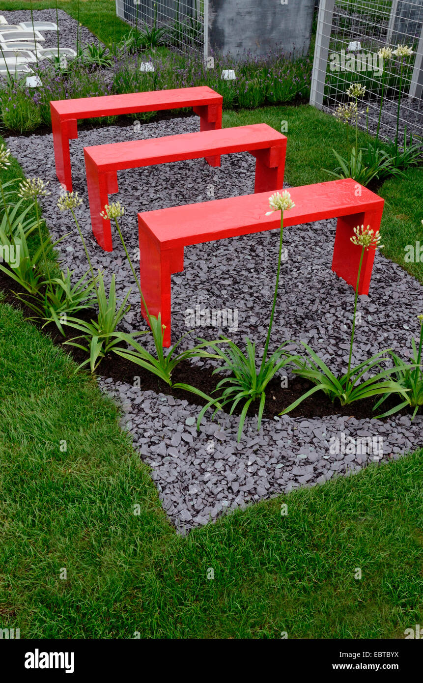 A garden design based on ciphers and hidden meanings with picture showing bright red benches with Agapanthus Stock Photo