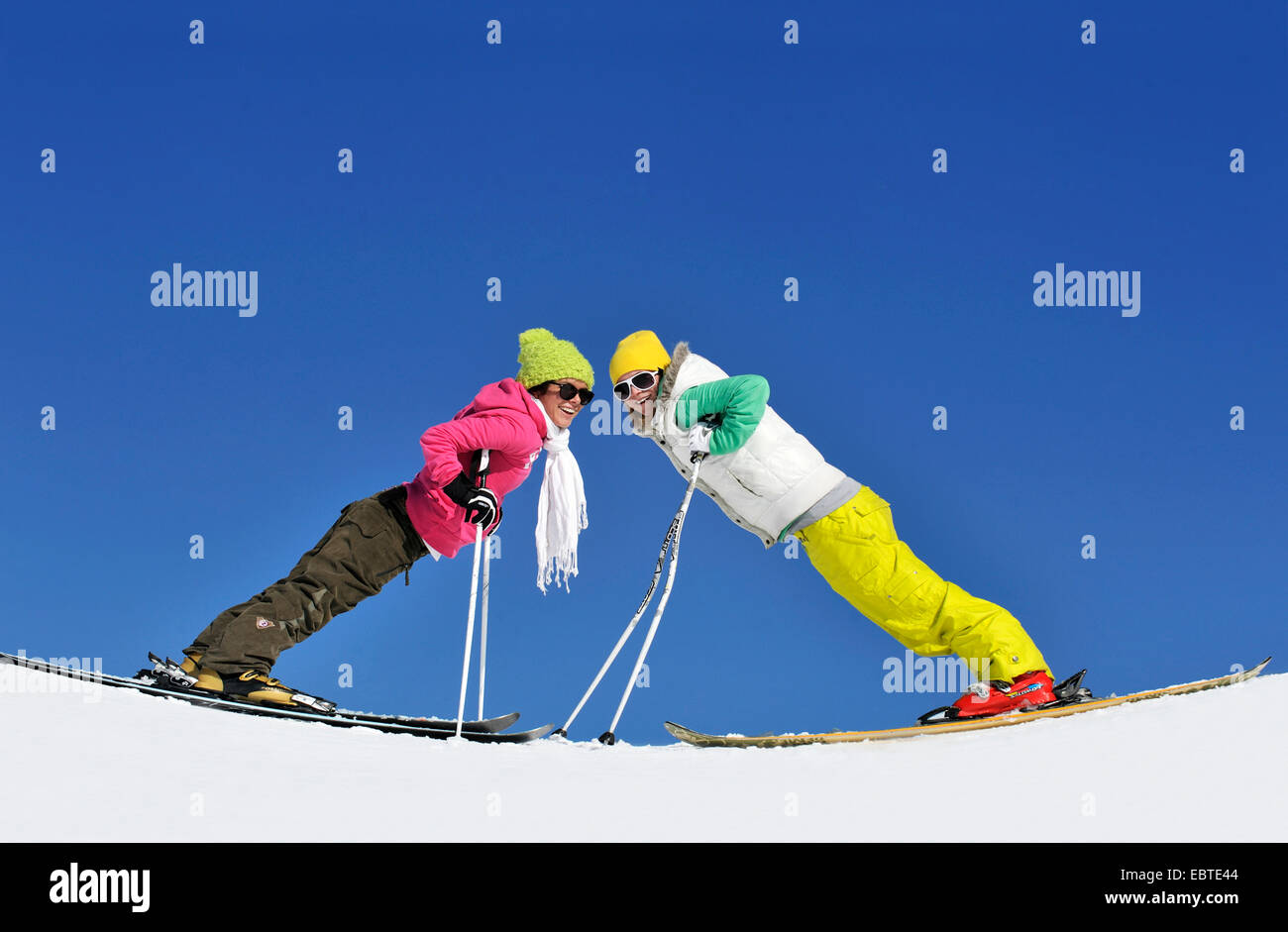 two teenagers standing vis-a-vis on skis and bending forwards, France Stock Photo