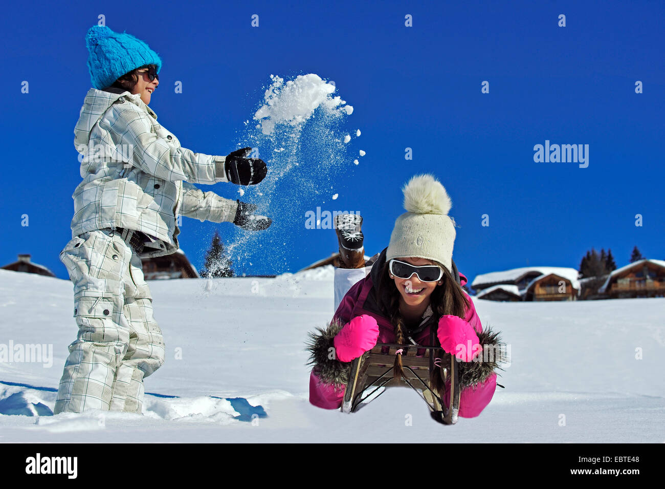 two siblings amusing themselves with snow and a toboggan, France Stock Photo