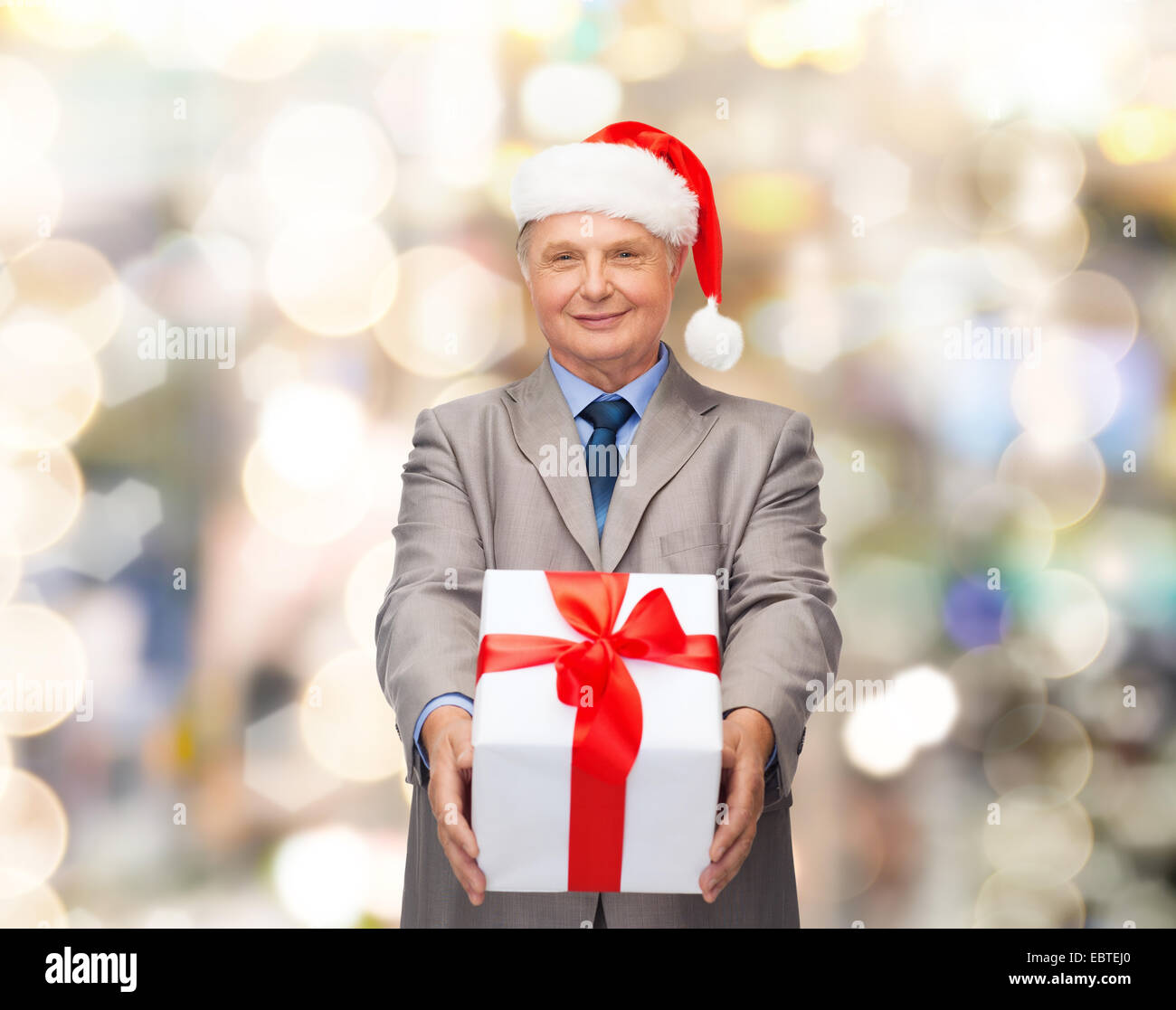 smiling man in suit and santa helper hat with gift Stock Photo - Alamy