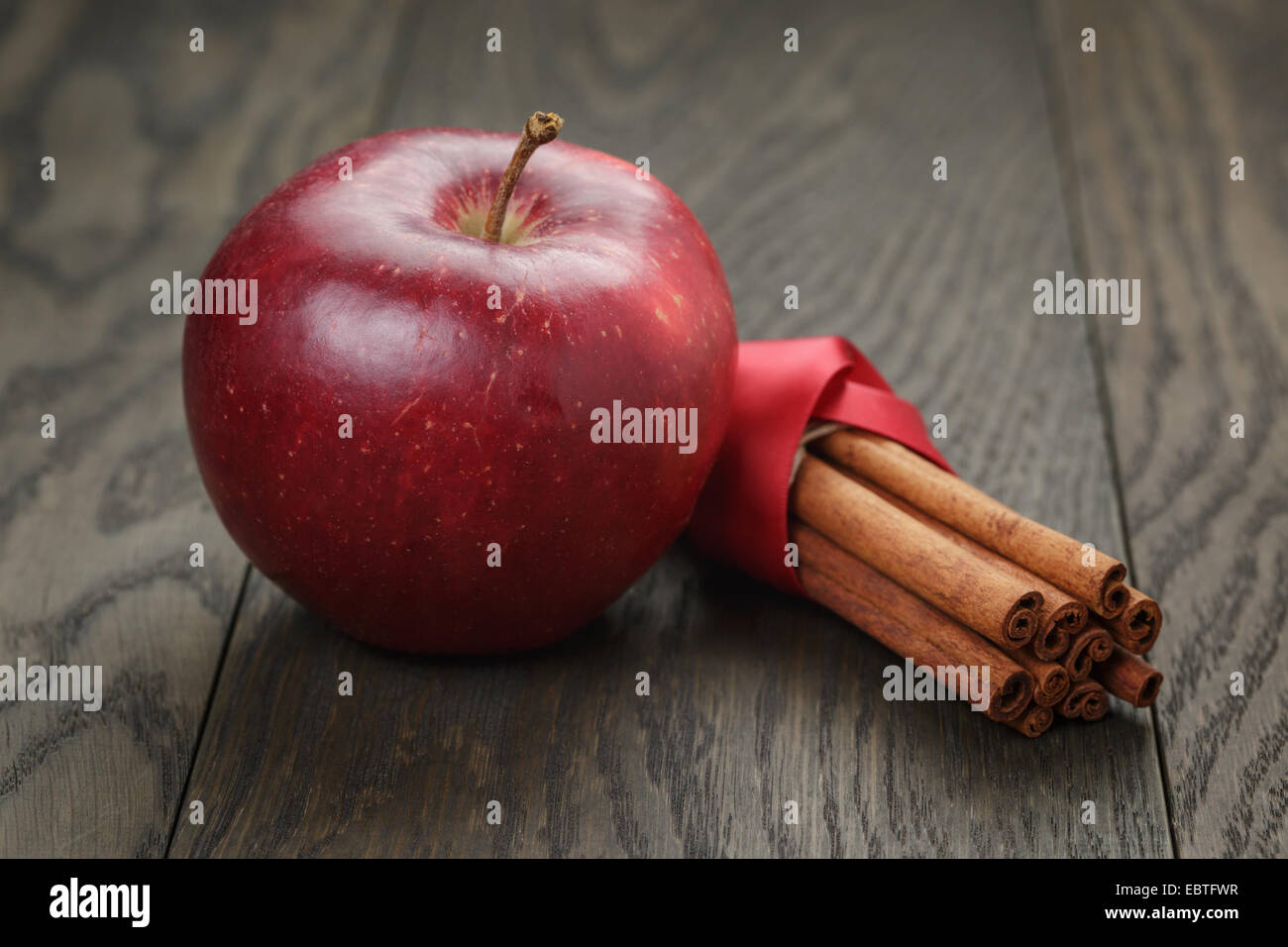 https://c8.alamy.com/comp/EBTFWR/red-ripe-apple-and-cinnamon-on-old-oak-table-EBTFWR.jpg