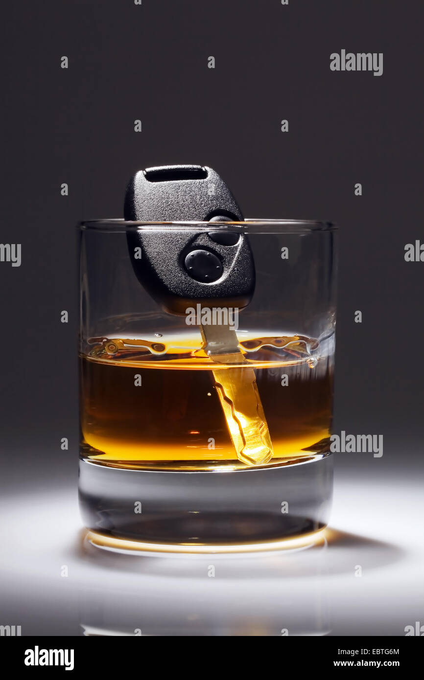 car key sinking in a glass of alcohol Stock Photo