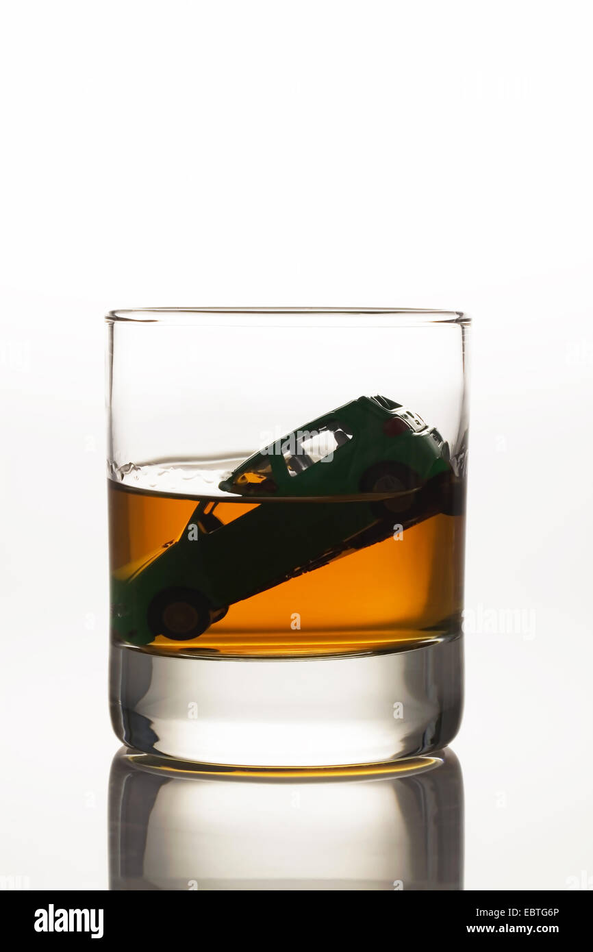 toy car sinking in a glass of alcohol Stock Photo
