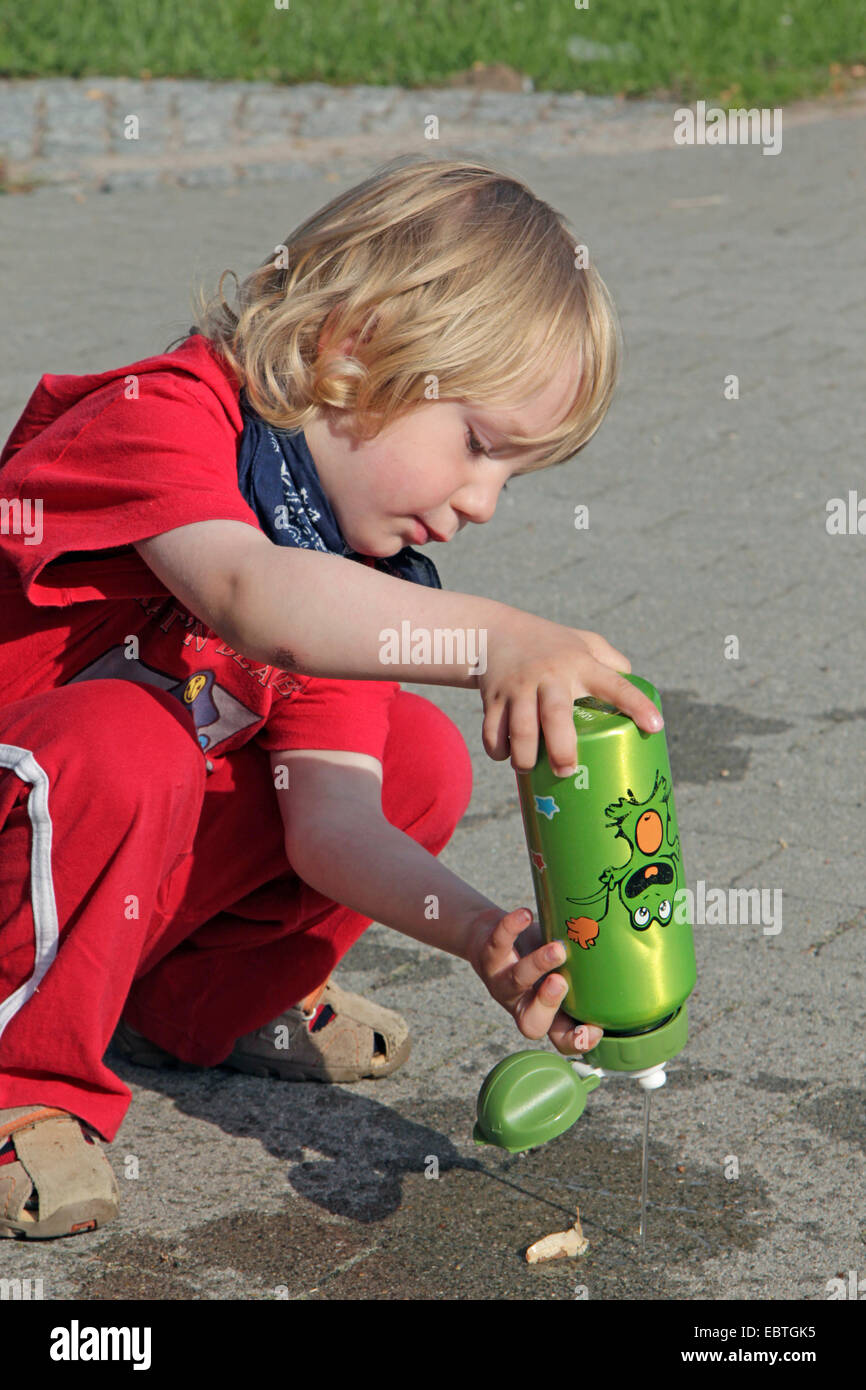 three-year-old boy playing with his drinking bottle, Germany Stock Photo