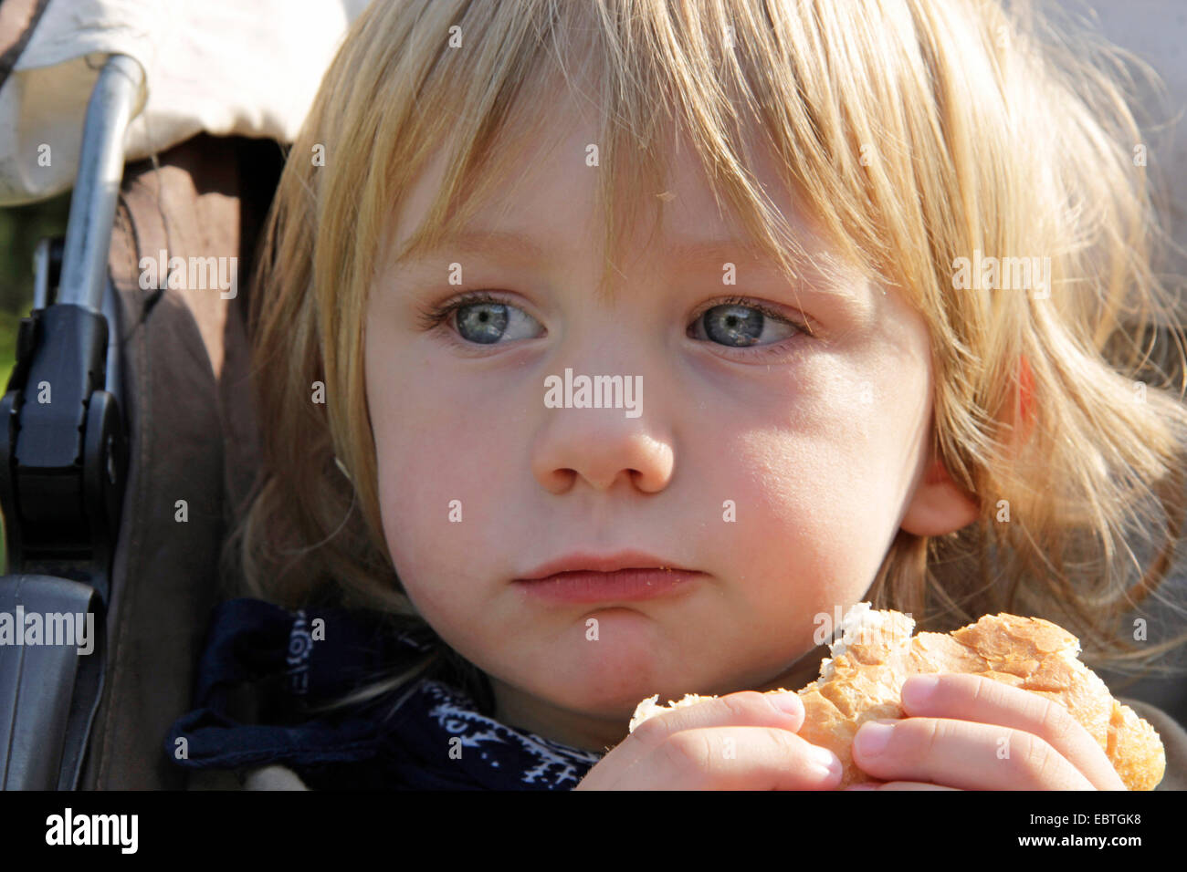 little boy eating a bread roll, Germany Stock Photo