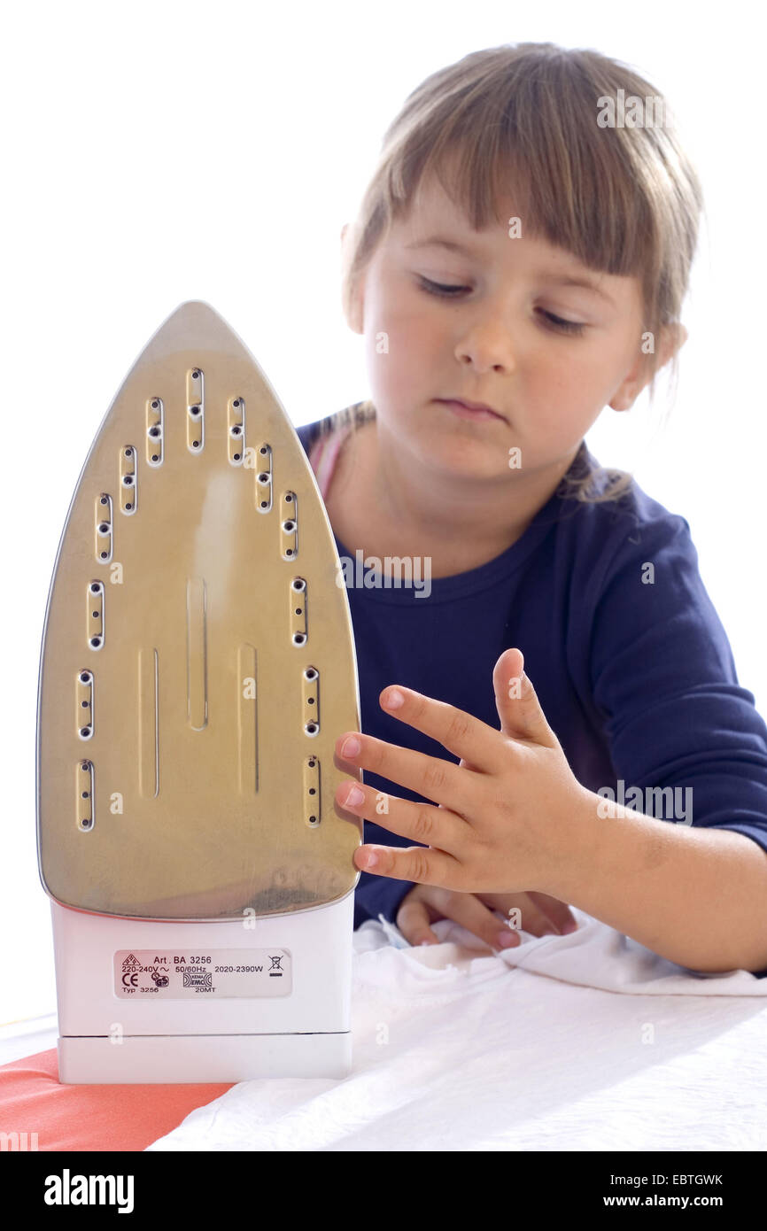 little girl touching carelessness a flat iron Stock Photo Alamy