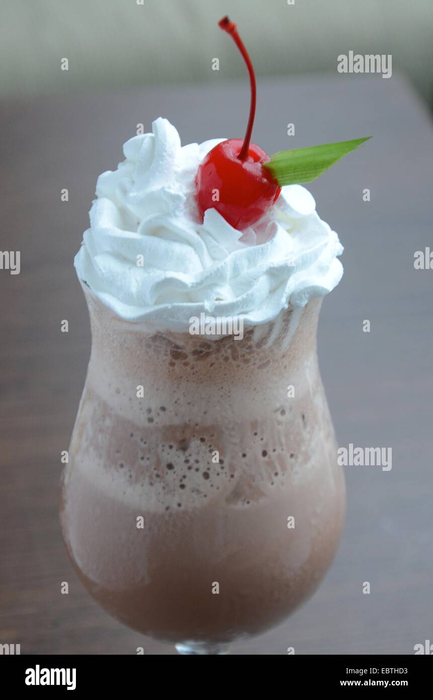 chocolate milkshake with frosting wipe cream and cherry on tob Stock Photo