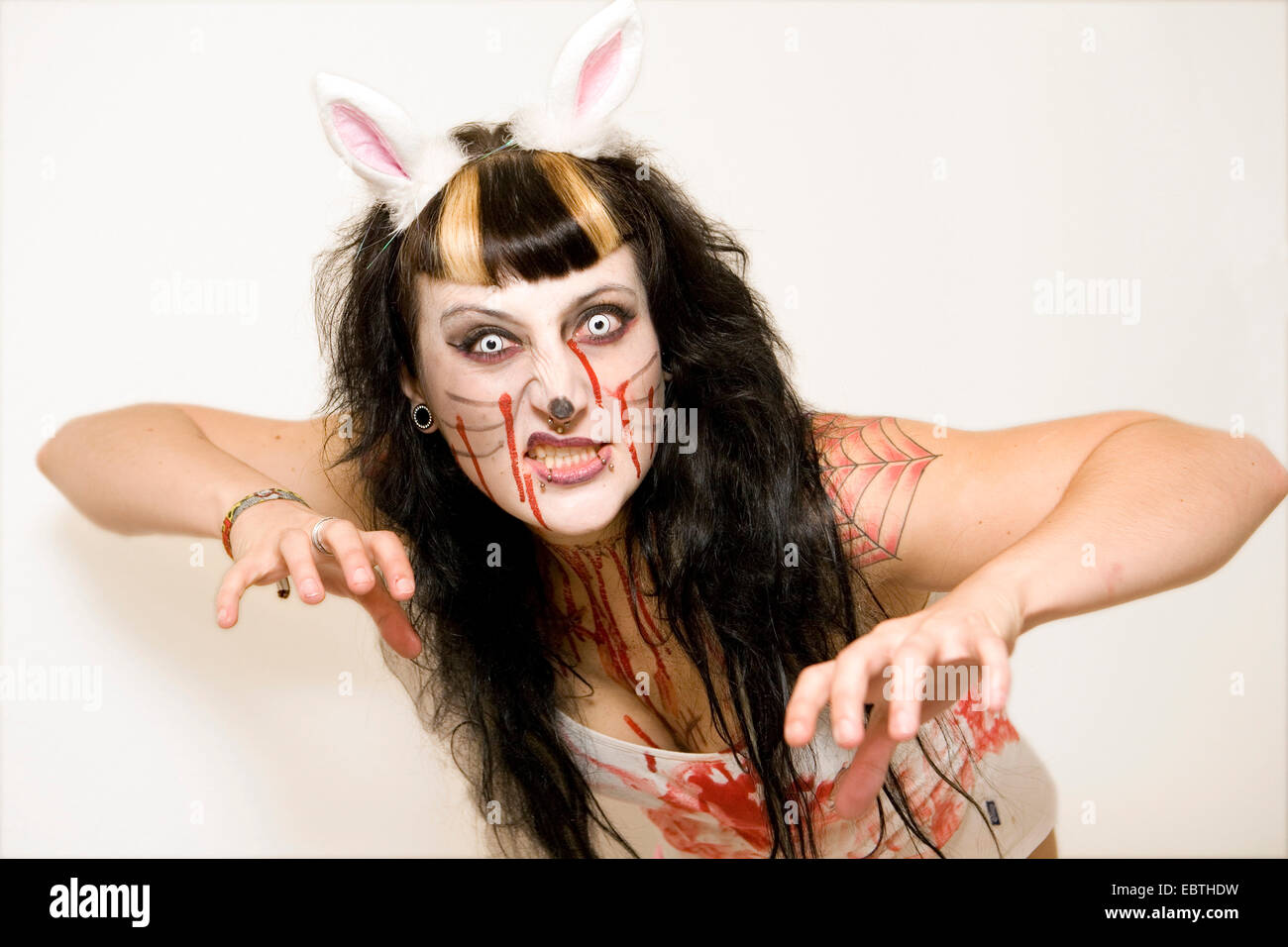 young woman wearing a Halloween costum is making threatening gesture Stock Photo