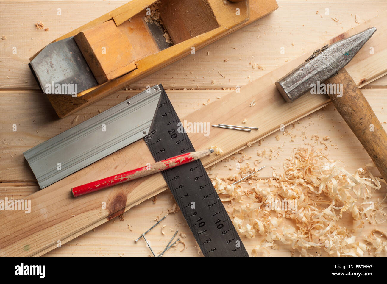 carpenter tools,hammer,meter, nails,shavings, and plane over wooden ...