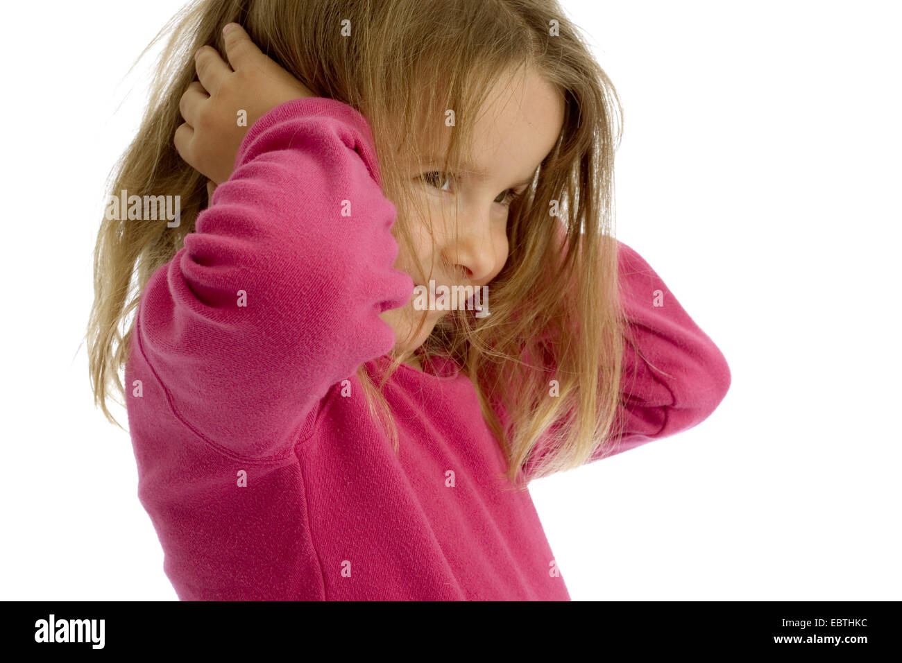 little girl holding her ears shut with a smile Stock Photo