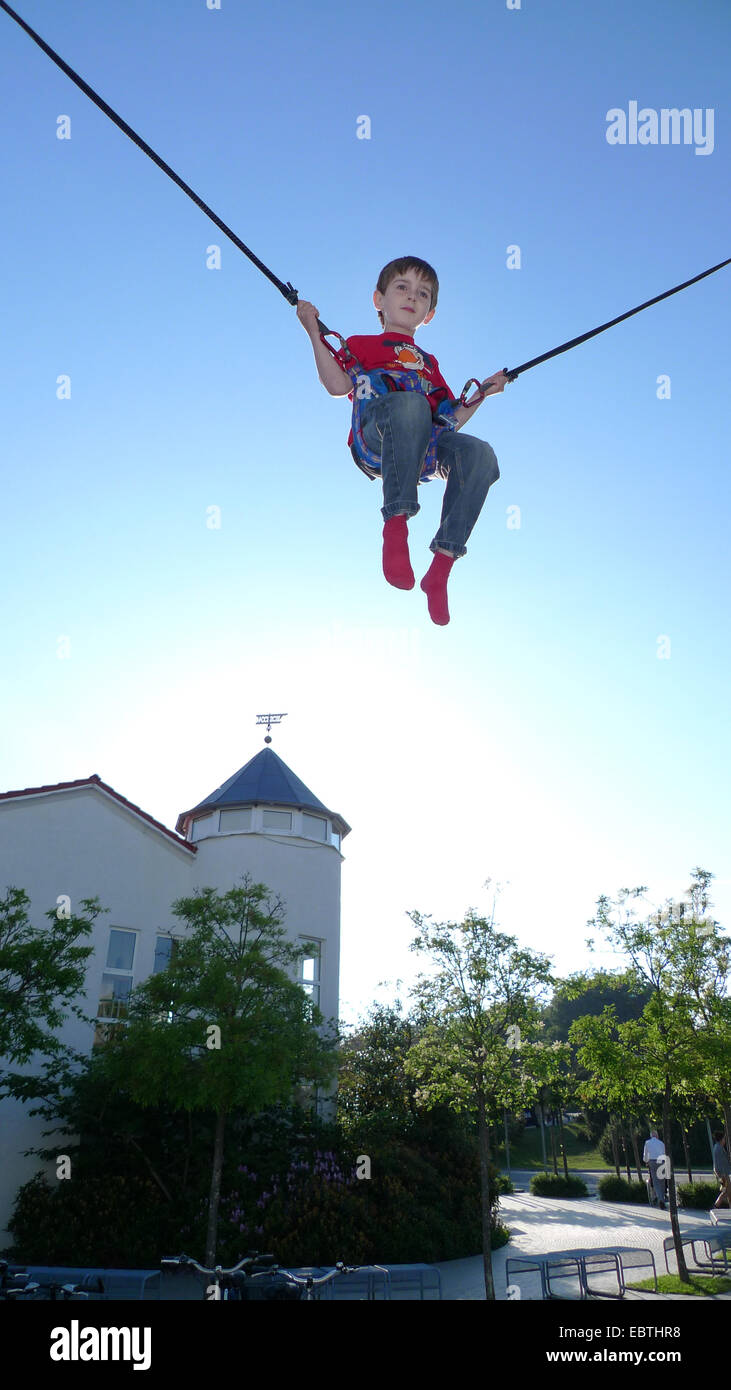 little boy jumping on bungee trampoline Stock Photo - Alamy