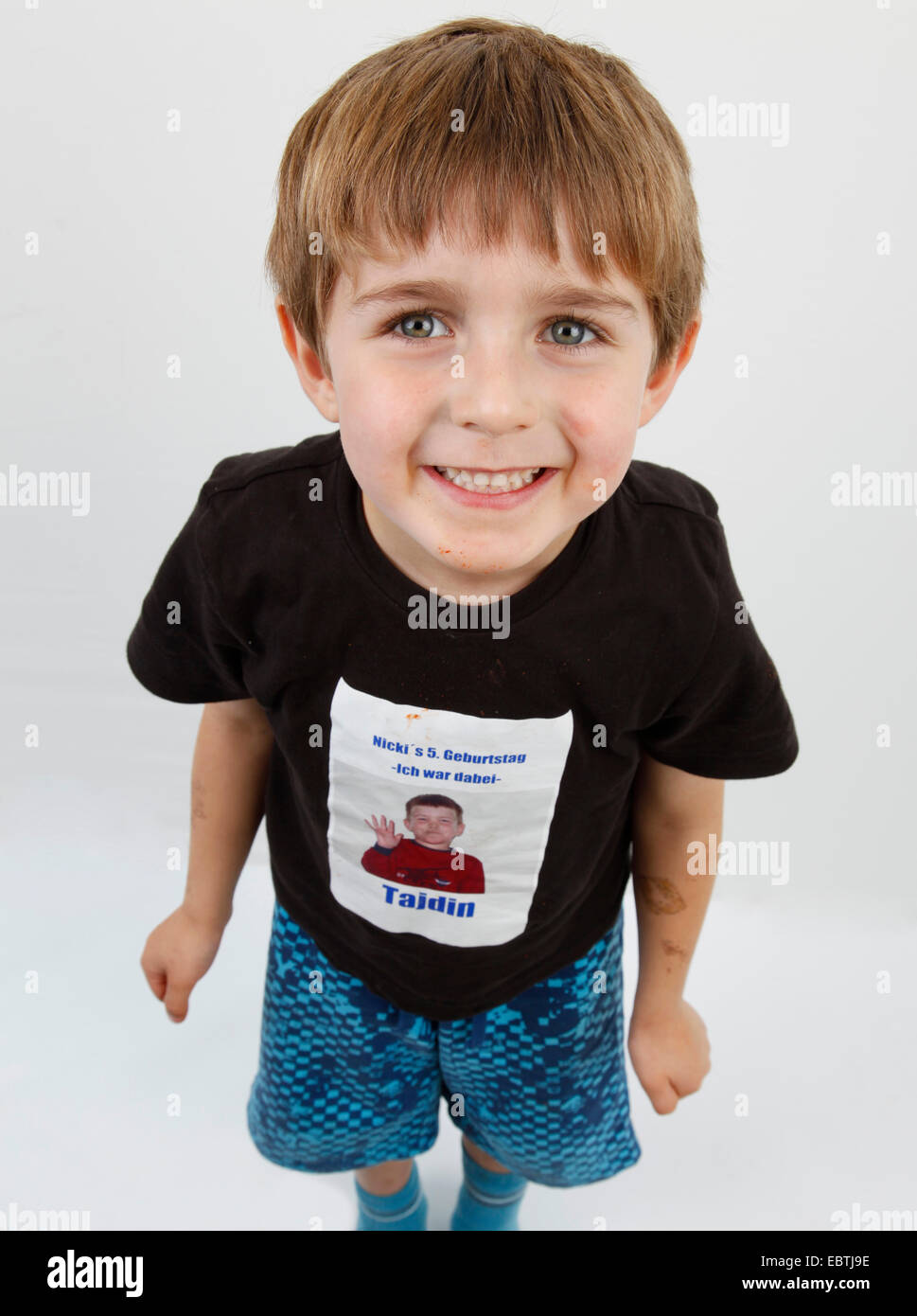little boy proudly presenting his T-shirt from a child's birthday Stock Photo