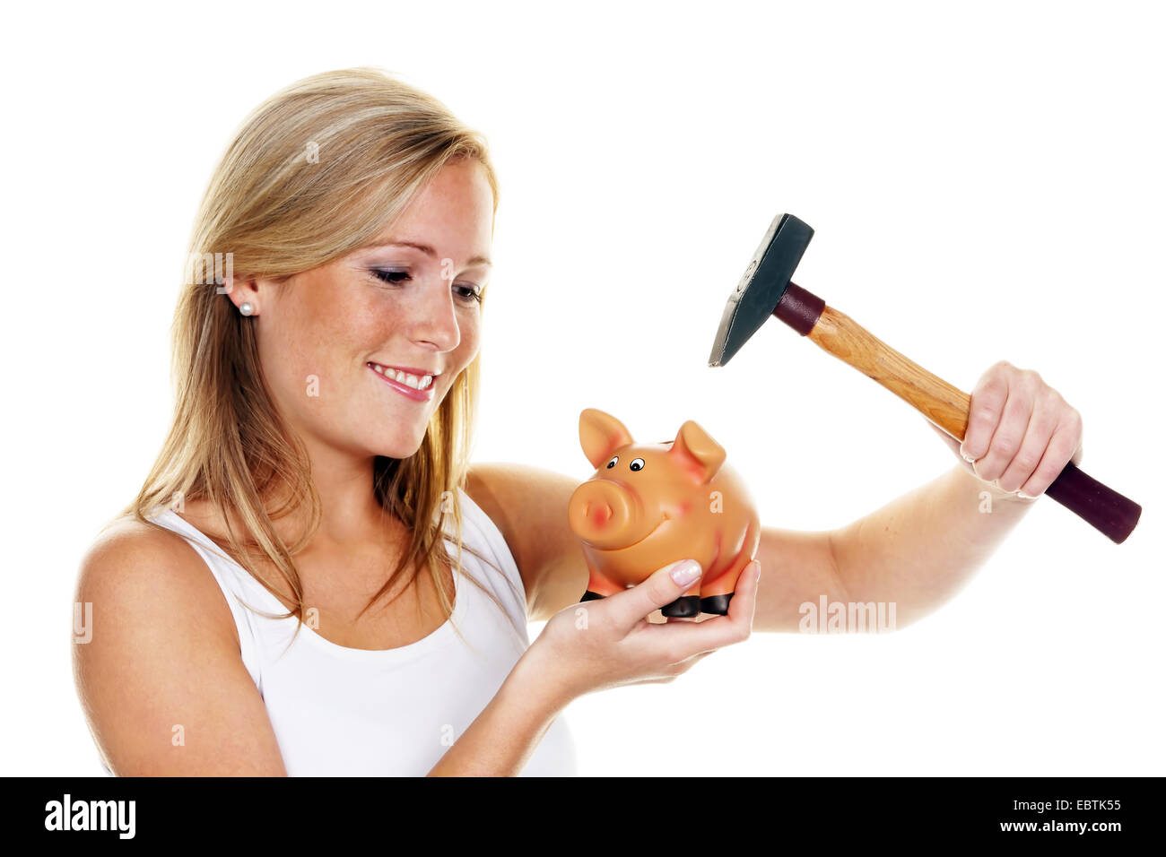 young woman with a hammer killing her piggy bank Stock Photo