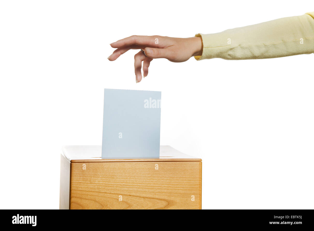 woman gives her vote at an election, a ballot box in polling station Stock Photo