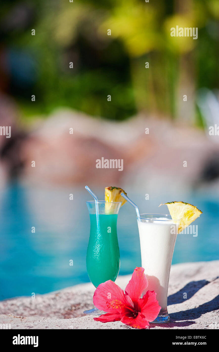 two tropical cocktails and hibiscus flower near swimming pool Stock Photo
