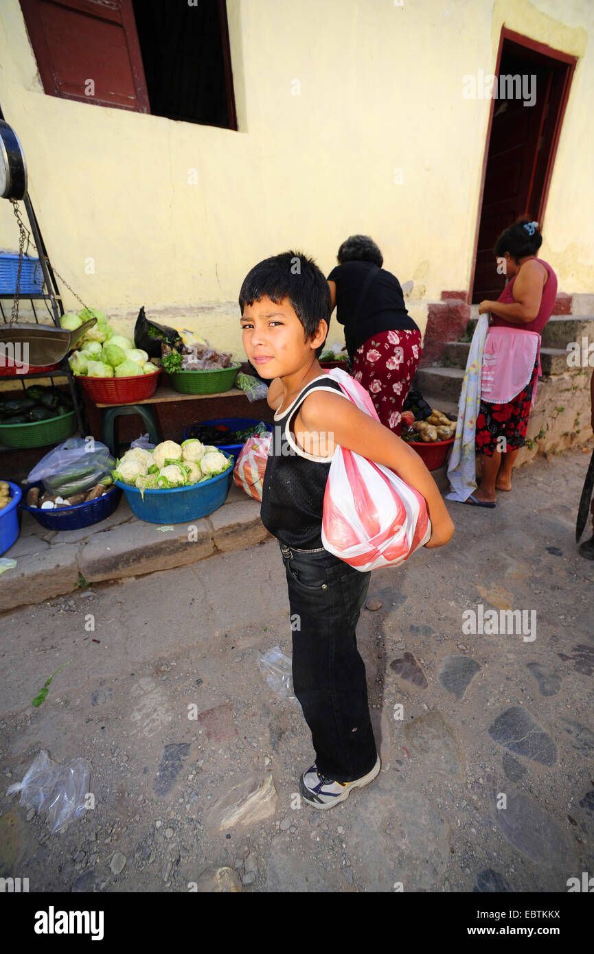 little boy standing infront of a market stall, Honduras Stock Photo