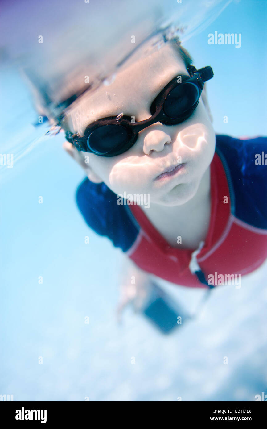 little boy wearing swimming goggles diving with an underwater camera in hands Stock Photo Alamy
