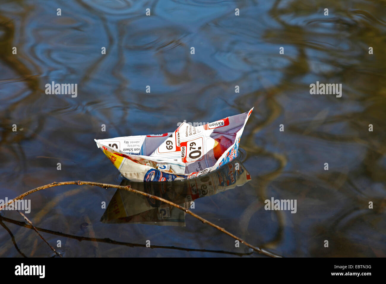 wrinkled paper boat on water Stock Photo