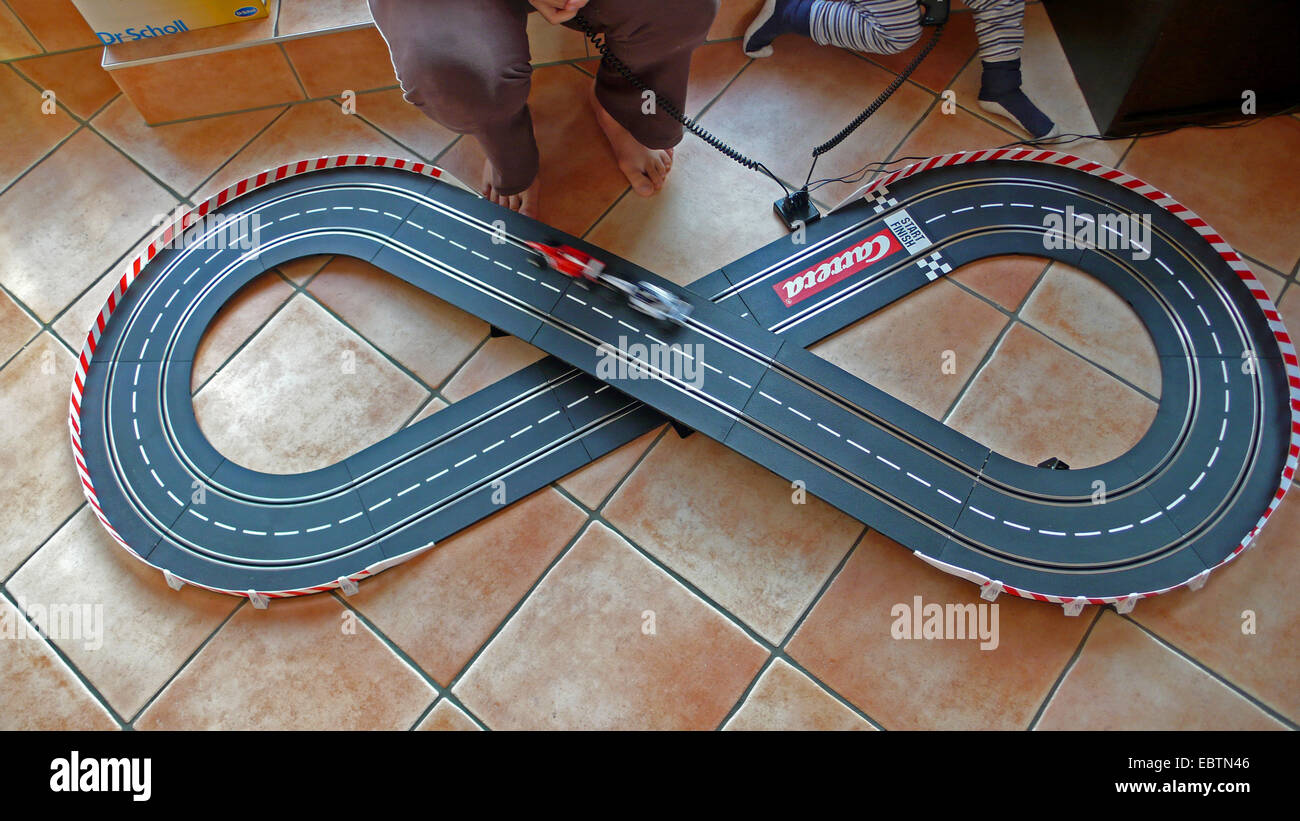 boy and mother playing with a slot car racing track Stock Photo