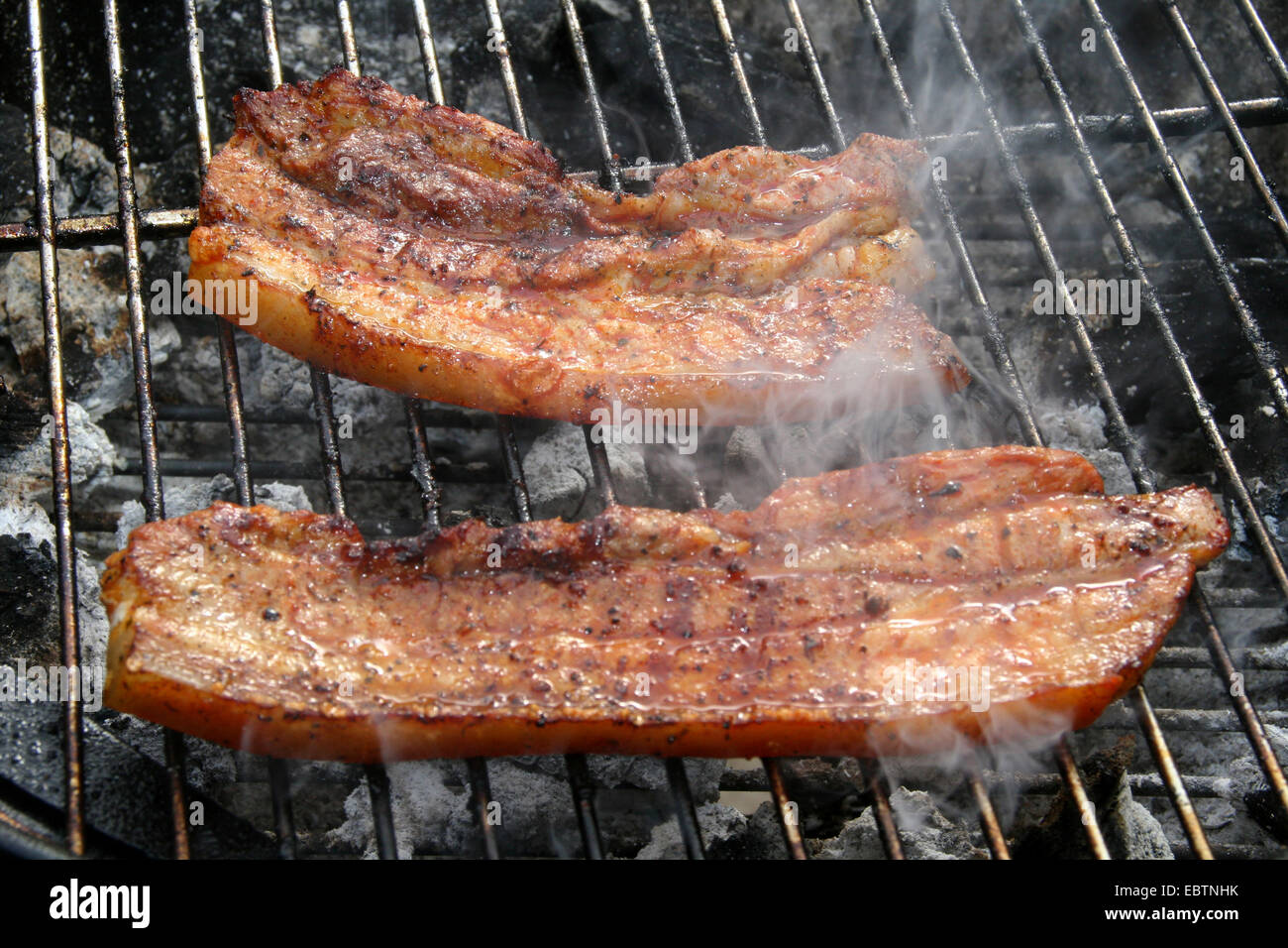 pork belly on a charcoalgrill, Germany, North RhineWestphalia Stock