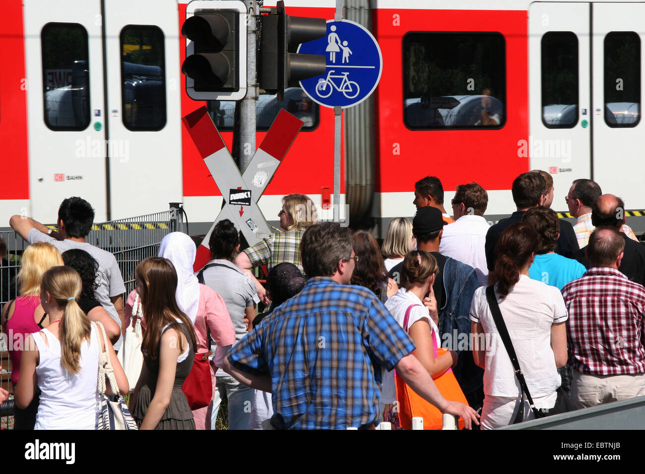 pedestrians waiting at railway crossing, Germany, North Rhine-Westphalia Stock Photo