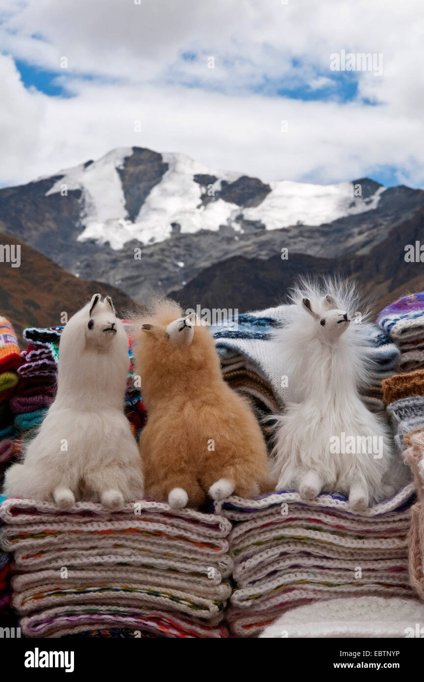soft toy llamas, hats and traditional blankets at a souvenir stand at the puno les desea feliz viaje pass, Peru, Feliz Viaje Stock Photo