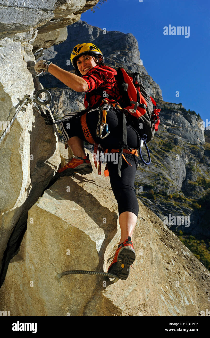 rock climber climbing a rock wall in Via ferrata of La Cascade, France, Savoie, Pralognan Stock Photo