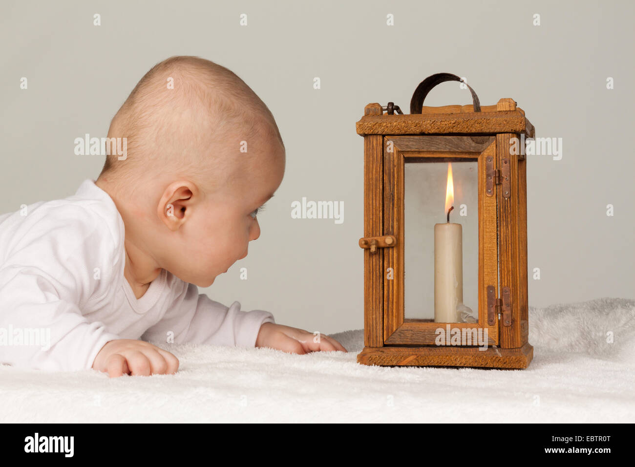 baby looking couriously at a burning candle Stock Photo