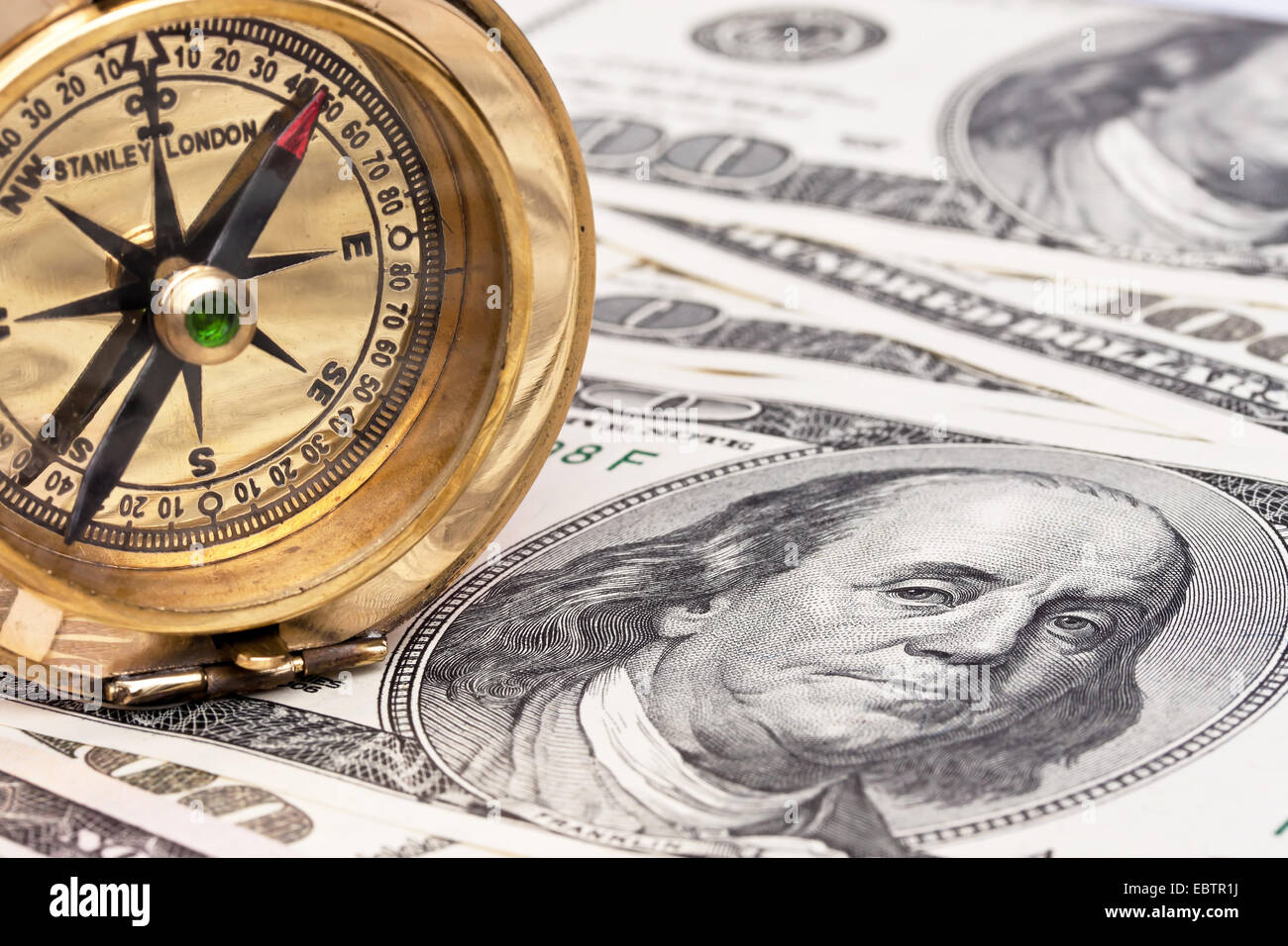 dollar bills and compass Stock Photo - Alamy