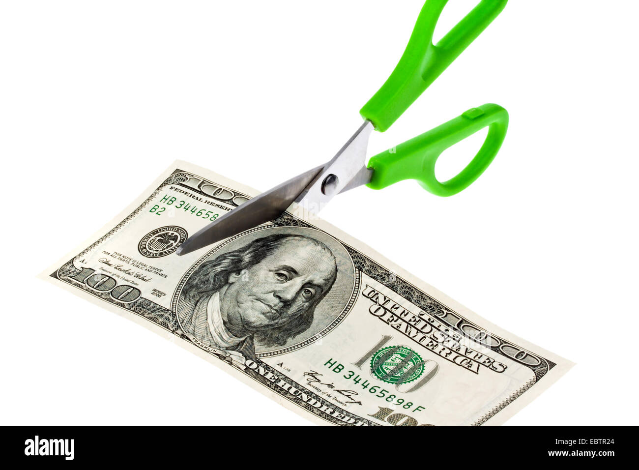 scissors cutting a Dollar banknote into pieces Stock Photo