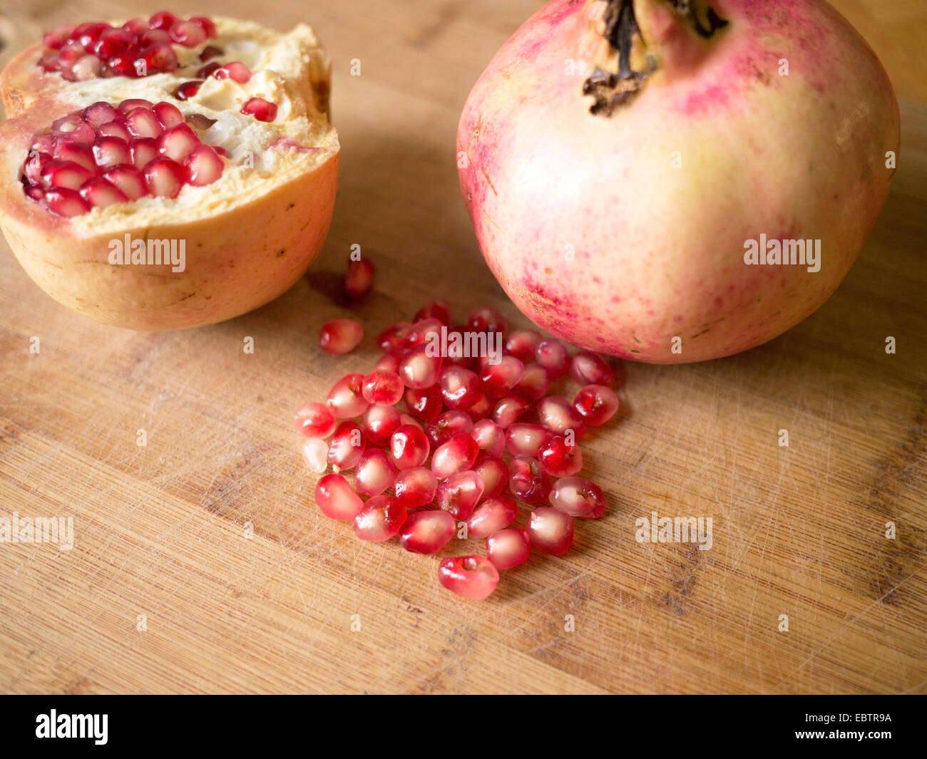 Pomegranate fruit on wooden board close up Stock Photo