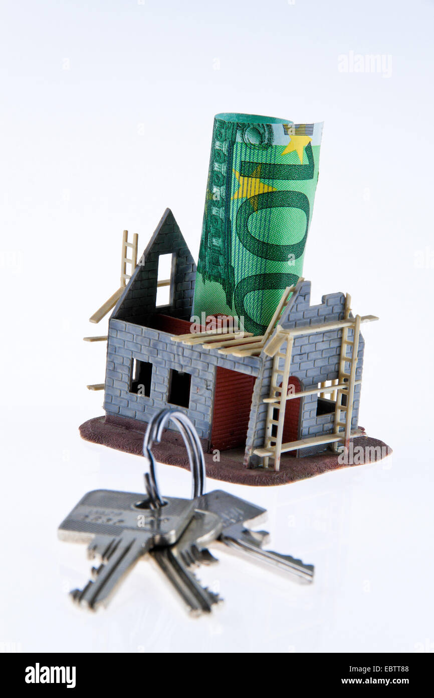 symbol picture 'housebuilding and financing': Euro bills sticking in the model of the shell construction of a house Stock Photo