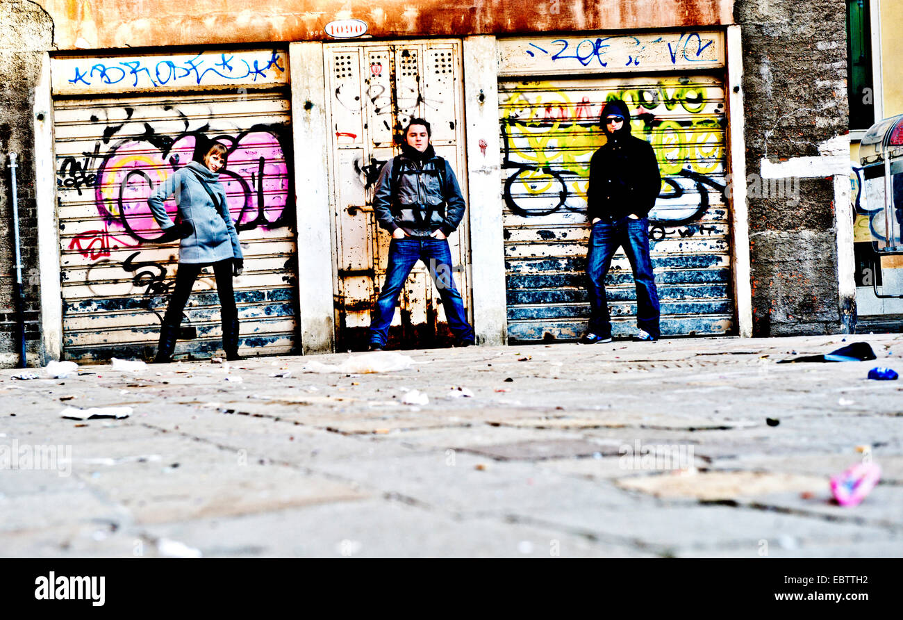 three teenager posing in front of a graffiti wall, Italy, Venice Stock Photo
