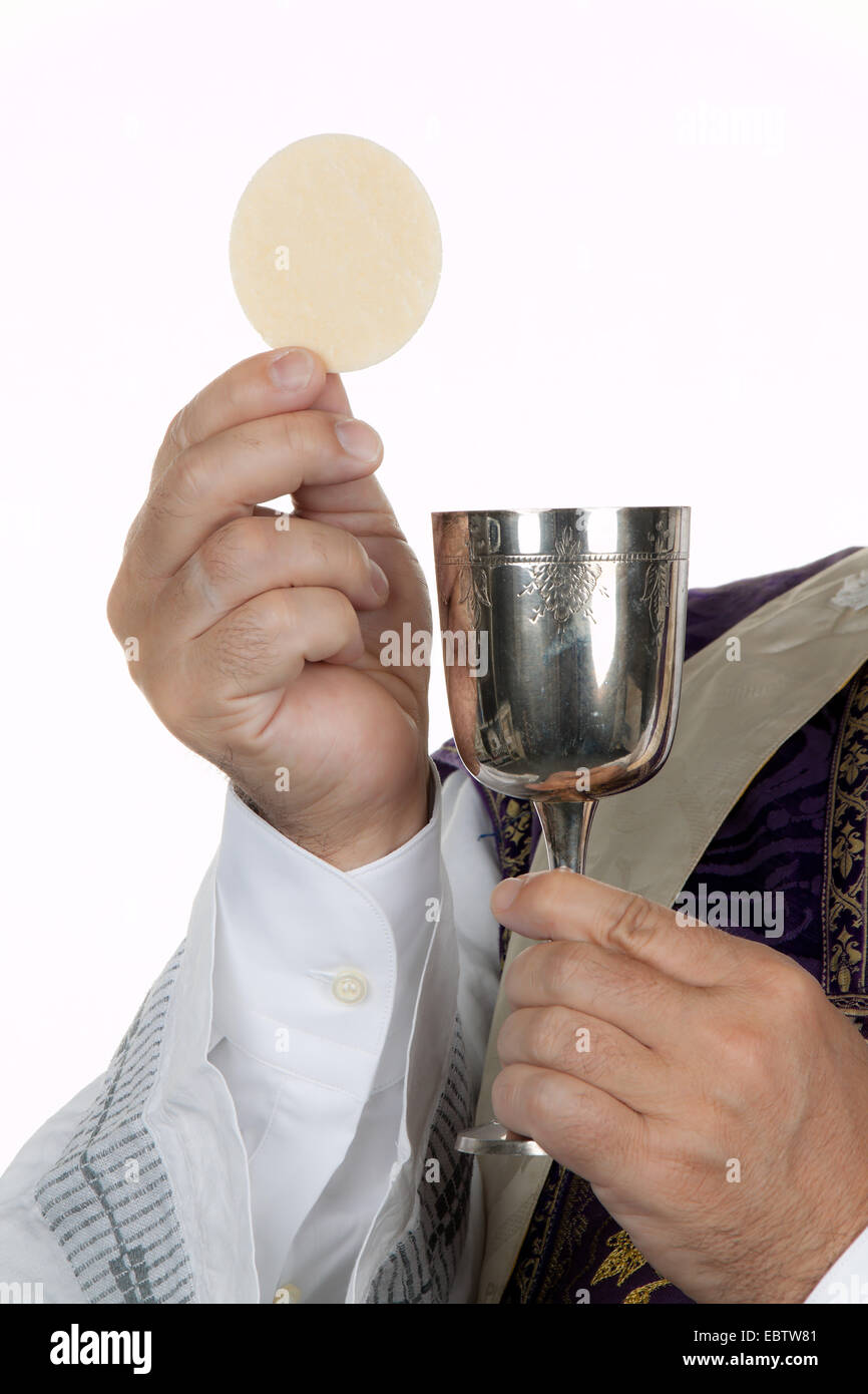 Catholic priest with a chalice and host at the Communion Stock Photo