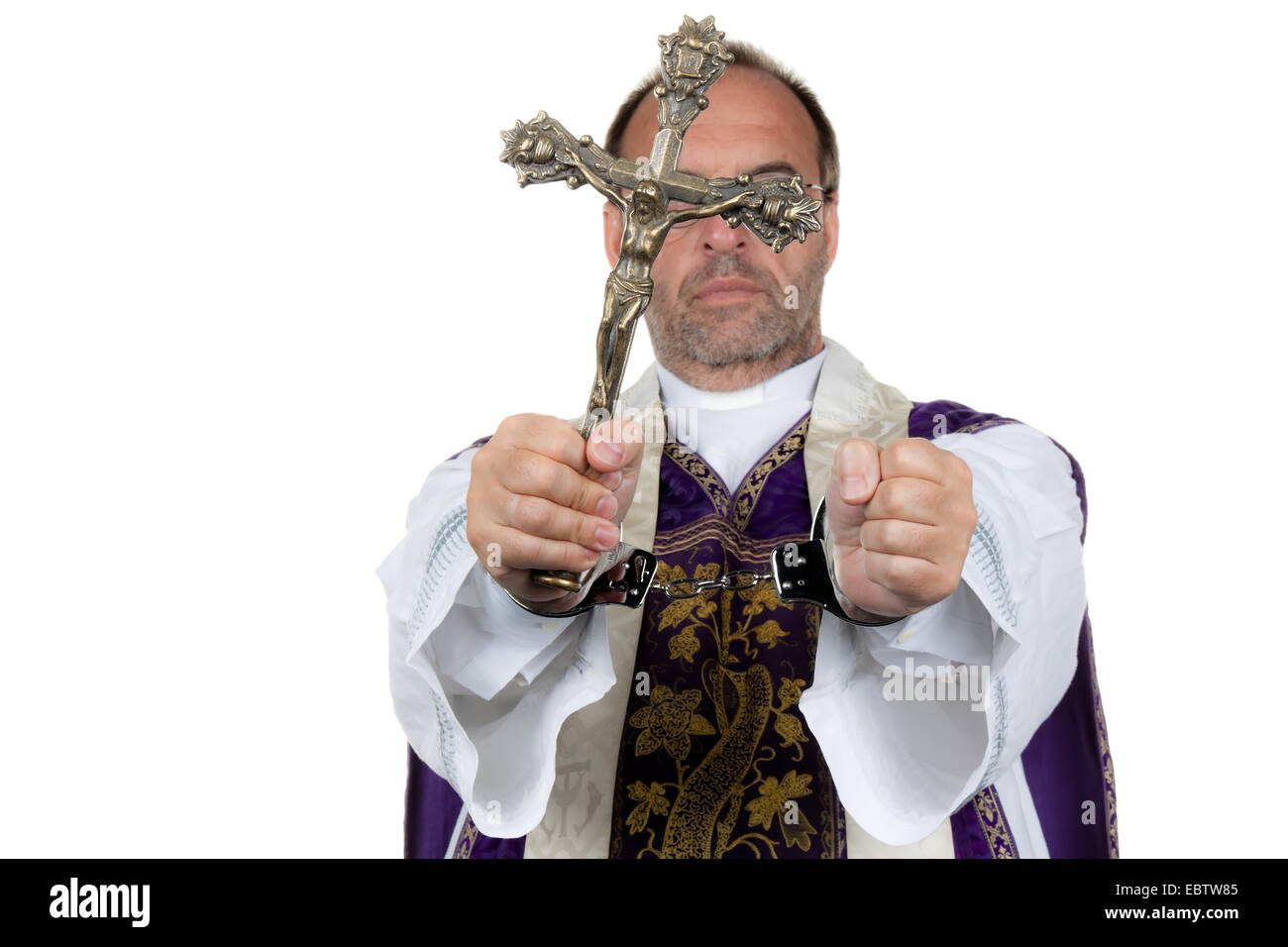 symbol picture 'child abuse in the church': priest with a cross in handcuffls Stock Photo