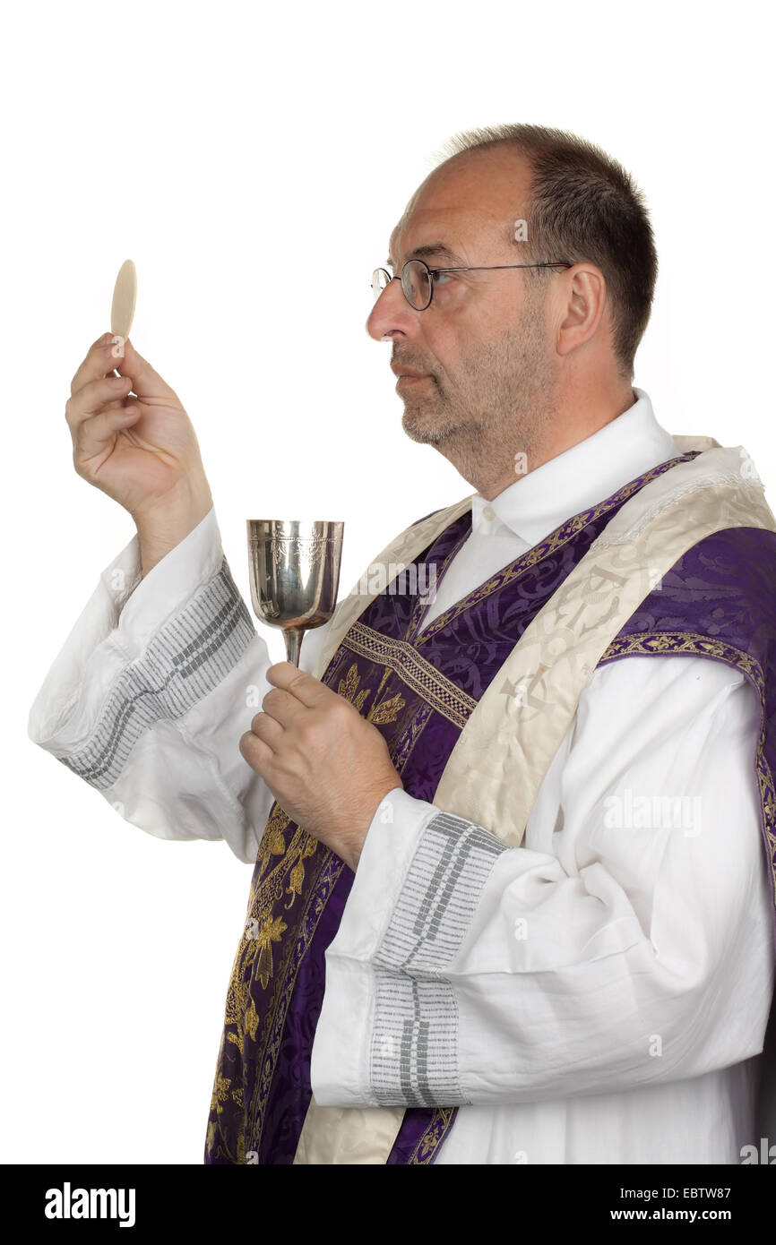 Catholic priest with a chalice and host at the Communion Stock Photo