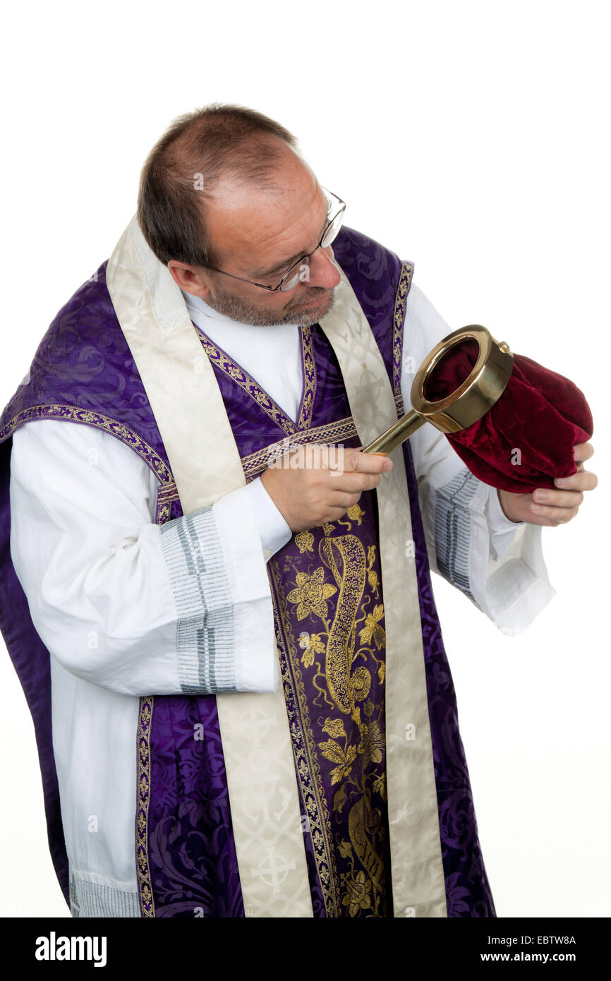 Catholic priest looking into an almsbag for collecting money for church projects Stock Photo