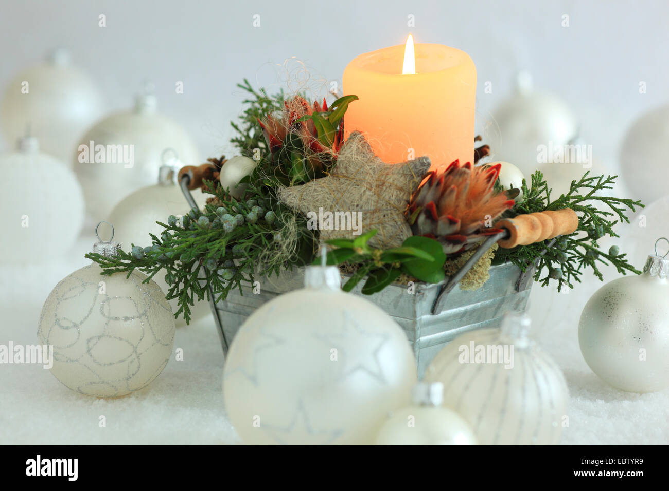 Christmas floral arrangement with candle and Christmas baubles Stock Photo